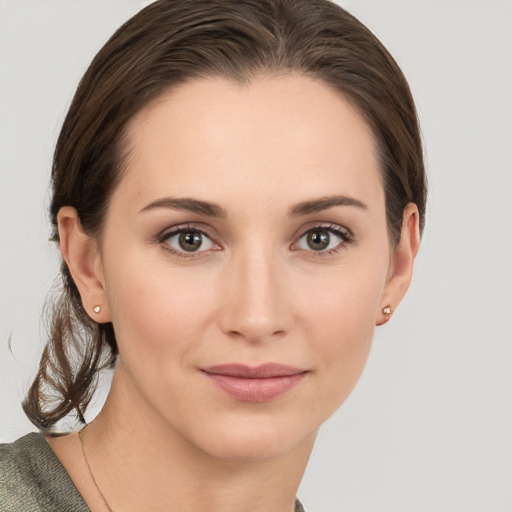 Joyful white young-adult female with medium  brown hair and grey eyes