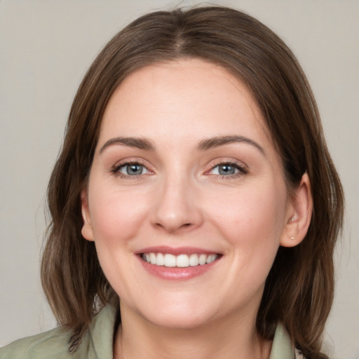 Joyful white young-adult female with medium  brown hair and green eyes