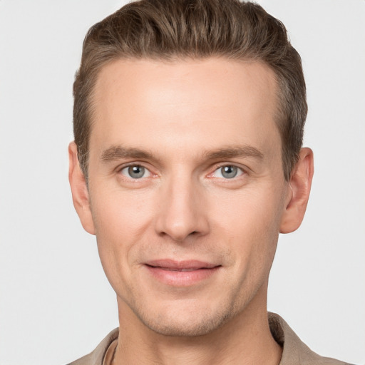 Joyful white young-adult male with short  brown hair and grey eyes