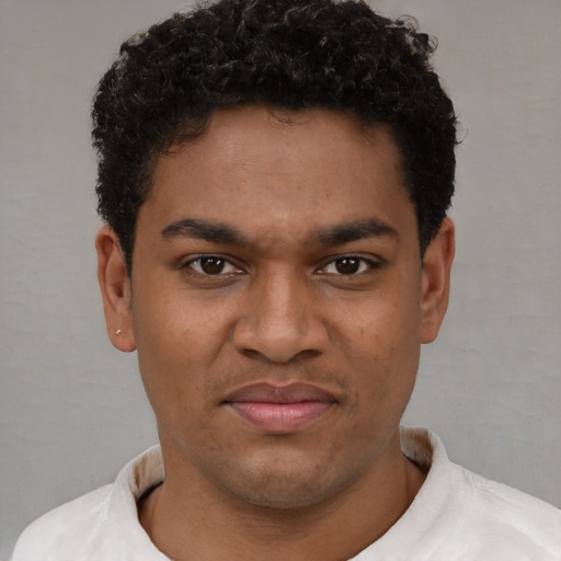 Joyful black young-adult male with short  brown hair and brown eyes
