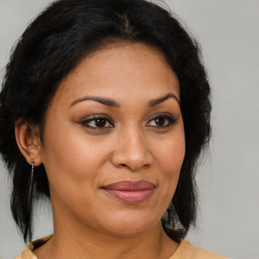 Joyful latino adult female with medium  brown hair and brown eyes