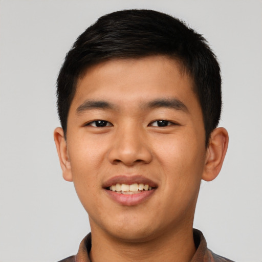 Joyful asian young-adult male with short  brown hair and brown eyes