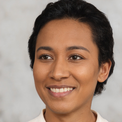 Joyful latino young-adult female with short  black hair and brown eyes