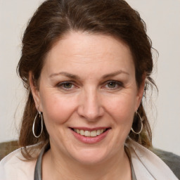 Joyful white adult female with medium  brown hair and brown eyes