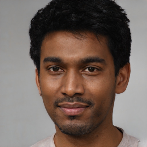 Joyful black young-adult male with short  black hair and brown eyes