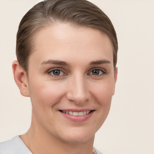 Joyful white young-adult female with short  brown hair and grey eyes