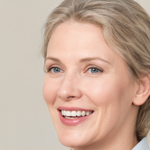 Joyful white adult female with medium  brown hair and blue eyes