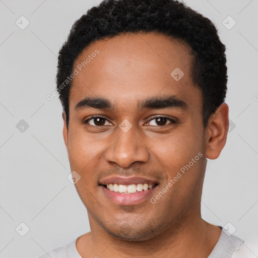 Joyful black young-adult male with short  black hair and brown eyes