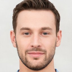 Joyful white young-adult male with short  brown hair and grey eyes