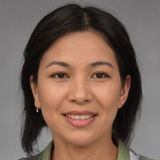 Joyful asian adult female with medium  brown hair and brown eyes