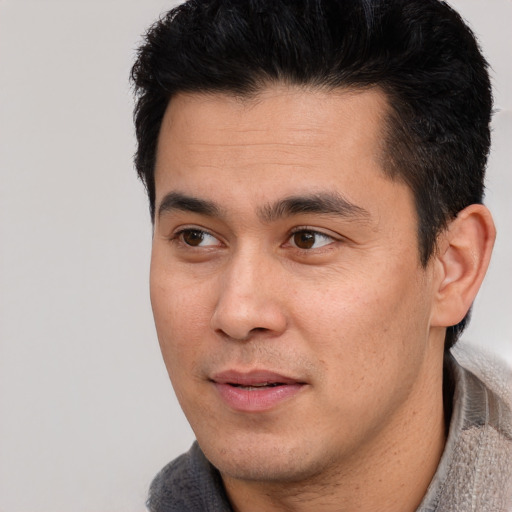 Joyful asian young-adult male with short  black hair and brown eyes