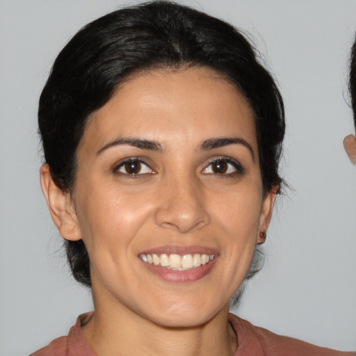 Joyful latino young-adult female with medium  brown hair and brown eyes