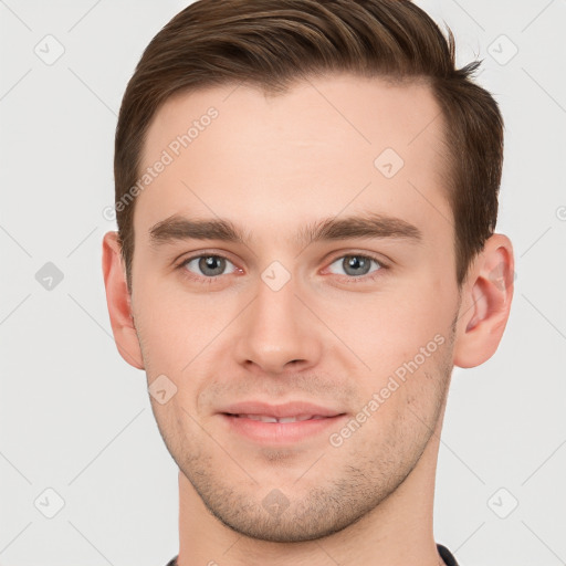 Joyful white young-adult male with short  brown hair and grey eyes