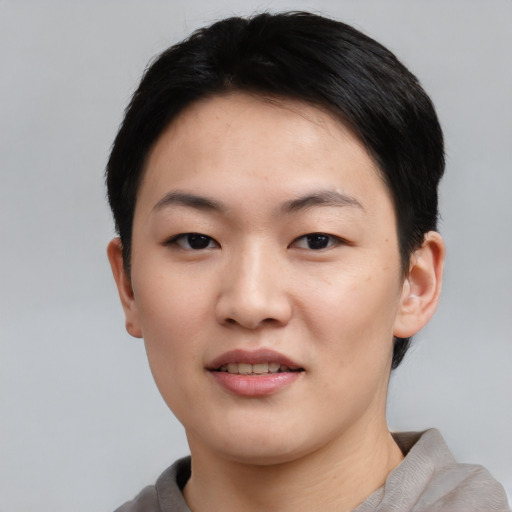 Joyful asian young-adult female with short  black hair and brown eyes