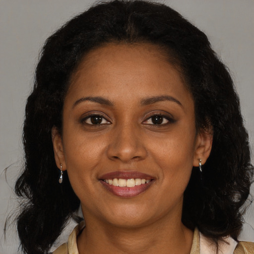 Joyful black young-adult female with long  brown hair and brown eyes