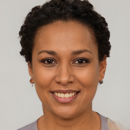 Joyful black adult female with short  black hair and brown eyes