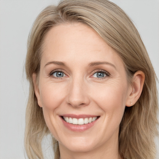 Joyful white adult female with medium  brown hair and blue eyes