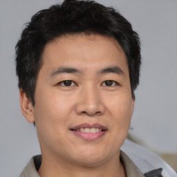 Joyful asian young-adult male with short  brown hair and brown eyes