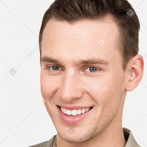 Joyful white young-adult male with short  brown hair and grey eyes