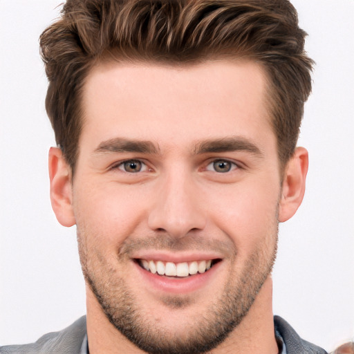 Joyful white young-adult male with short  brown hair and blue eyes