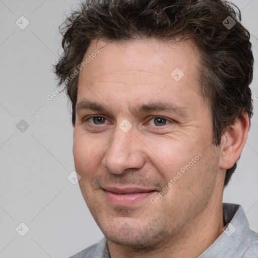 Joyful white adult male with short  brown hair and brown eyes