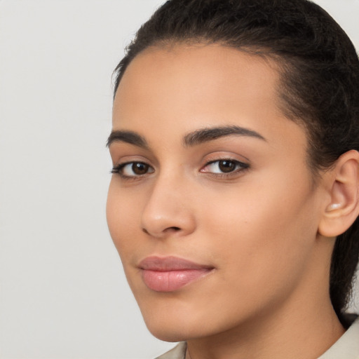 Joyful latino young-adult female with long  brown hair and brown eyes