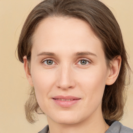 Joyful white young-adult female with medium  brown hair and grey eyes