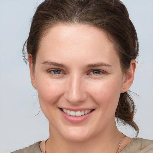 Joyful white young-adult female with medium  brown hair and grey eyes