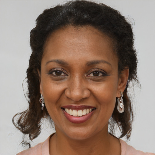 Joyful black adult female with long  brown hair and brown eyes