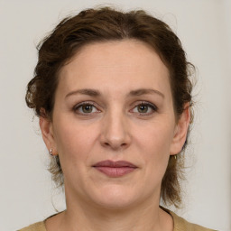 Joyful white adult female with medium  brown hair and grey eyes