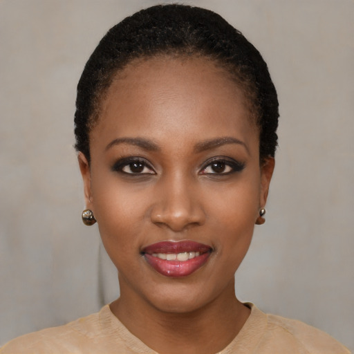 Joyful black young-adult female with short  black hair and brown eyes