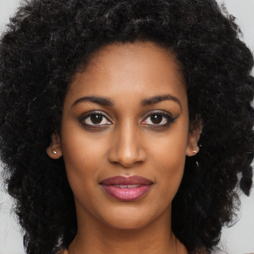 Joyful black young-adult female with long  black hair and brown eyes