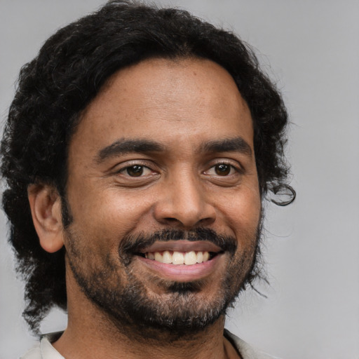 Joyful black adult male with short  black hair and brown eyes