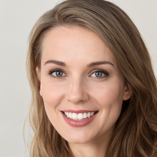 Joyful white young-adult female with long  brown hair and green eyes