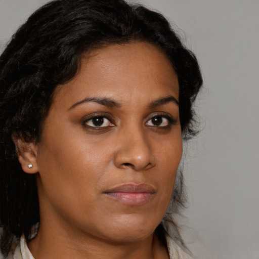 Joyful black young-adult female with long  brown hair and brown eyes