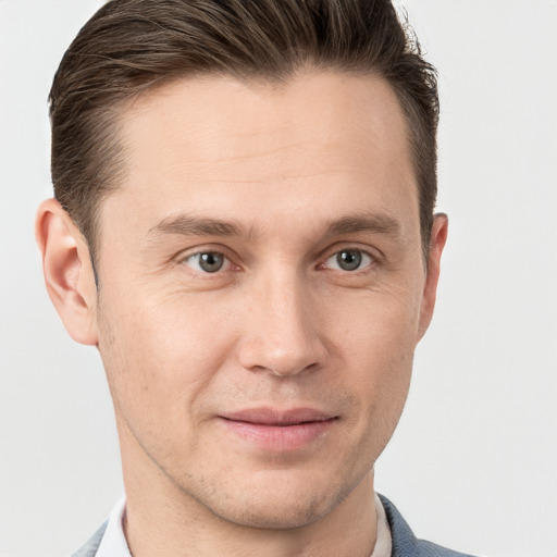 Joyful white young-adult male with short  brown hair and grey eyes