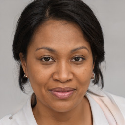 Joyful black adult female with medium  brown hair and brown eyes