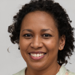 Joyful black adult female with medium  brown hair and brown eyes