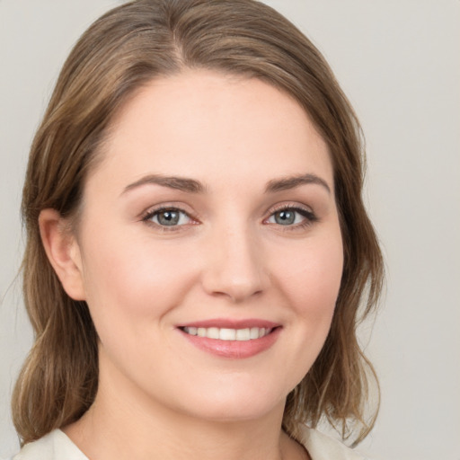 Joyful white young-adult female with medium  brown hair and green eyes