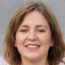 Joyful white adult female with medium  brown hair and grey eyes