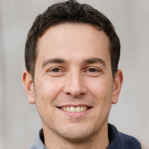 Joyful white adult male with short  brown hair and brown eyes