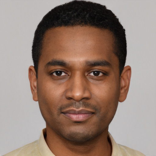 Joyful black young-adult male with short  black hair and brown eyes