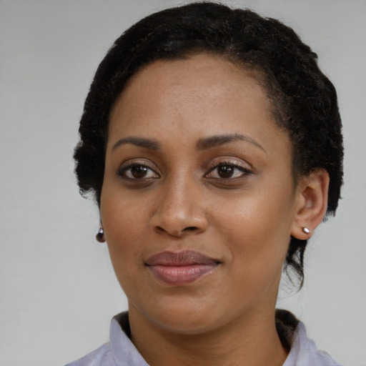 Joyful black young-adult female with short  brown hair and brown eyes