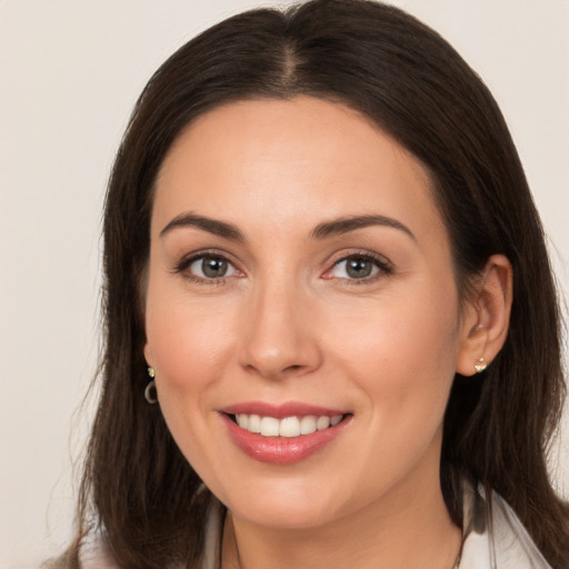 Joyful white young-adult female with long  brown hair and brown eyes