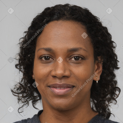 Joyful black adult female with long  brown hair and brown eyes