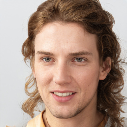 Joyful white young-adult male with medium  brown hair and grey eyes