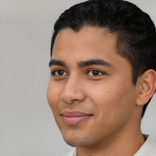 Joyful latino young-adult male with short  black hair and brown eyes