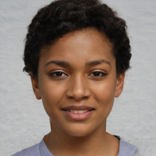 Joyful black young-adult female with short  black hair and brown eyes