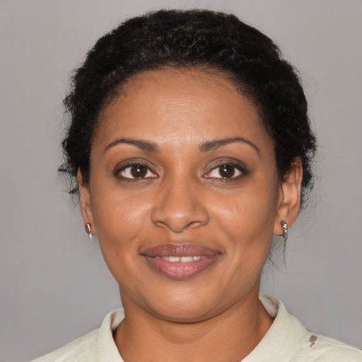 Joyful black adult female with short  black hair and brown eyes