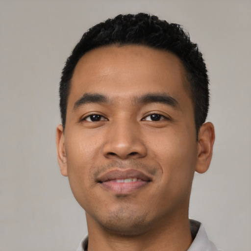 Joyful latino young-adult male with short  black hair and brown eyes